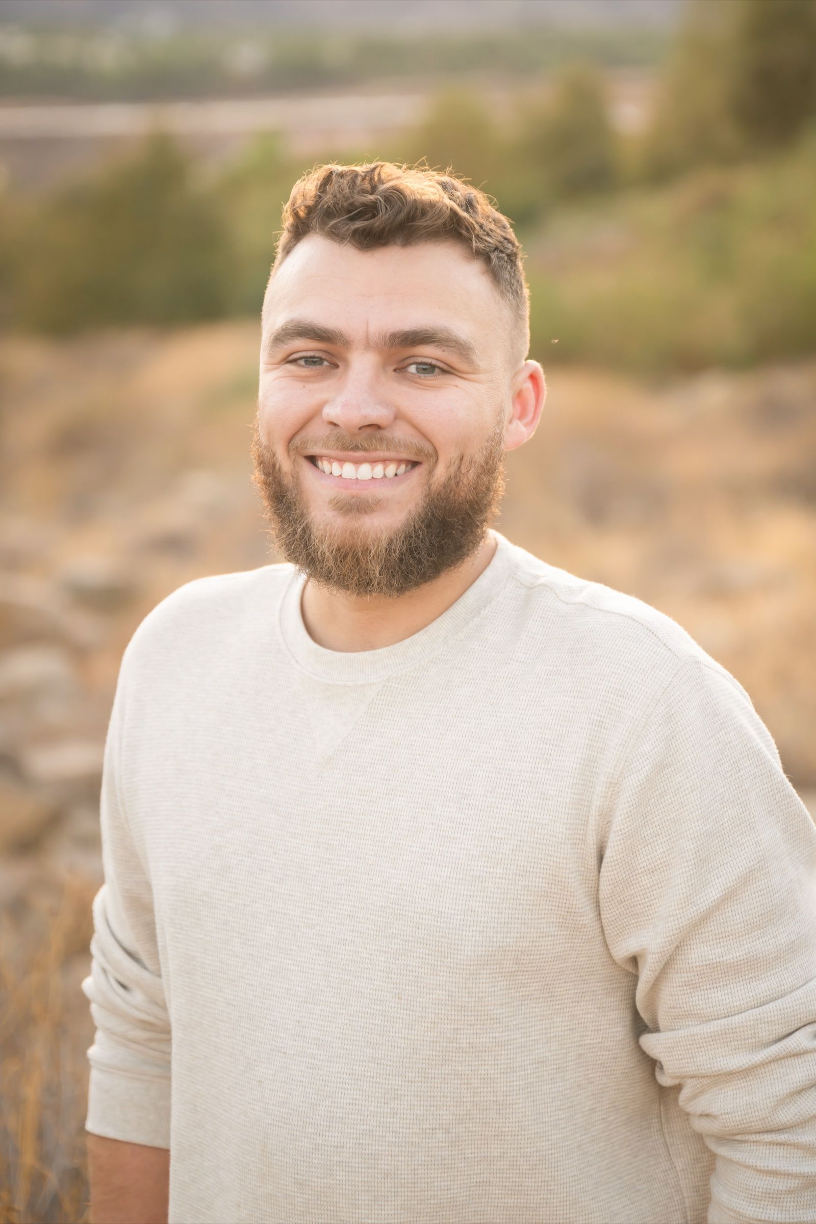 Austin Hulen, founder of Inland Logic, smiling outdoors in the Inland Empire hills
